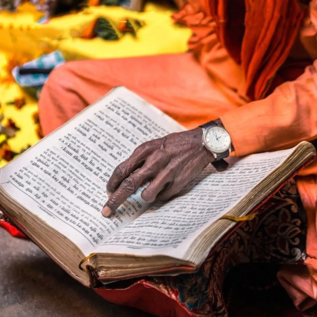 Ancient Hindu scriptures (Vedas), books, or a priest reading them.