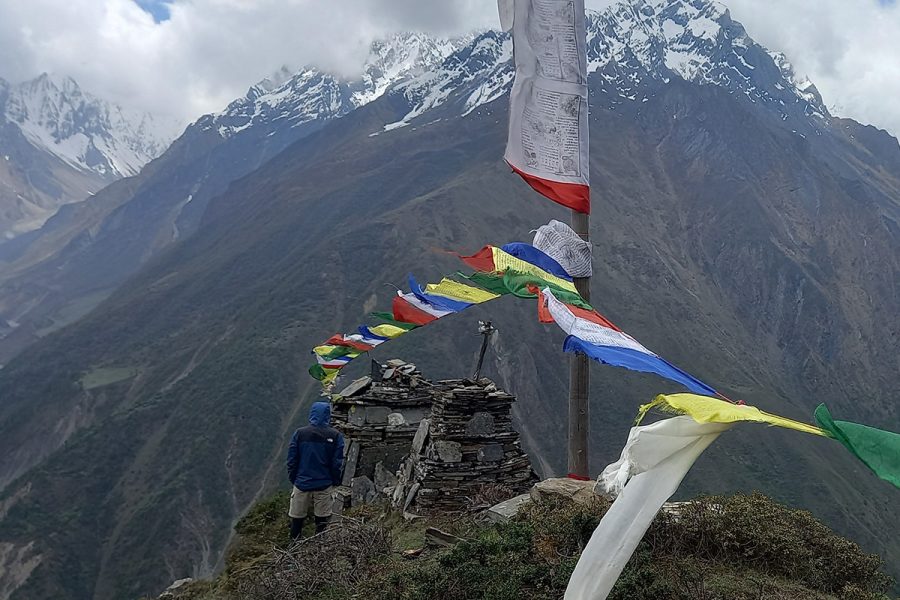 buddhist-prayer-flags-and-small-stone-temples-in-tsum-valley-showing-colorful-flags-and-white-structures-with-mountain-backdrop
